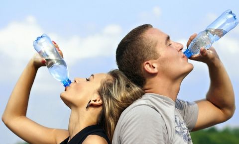 a folyton úton lévő ember PET-palackos vizet iszik